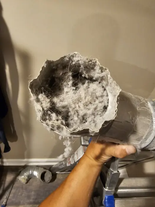 A solid plug of lint in a metal duct
